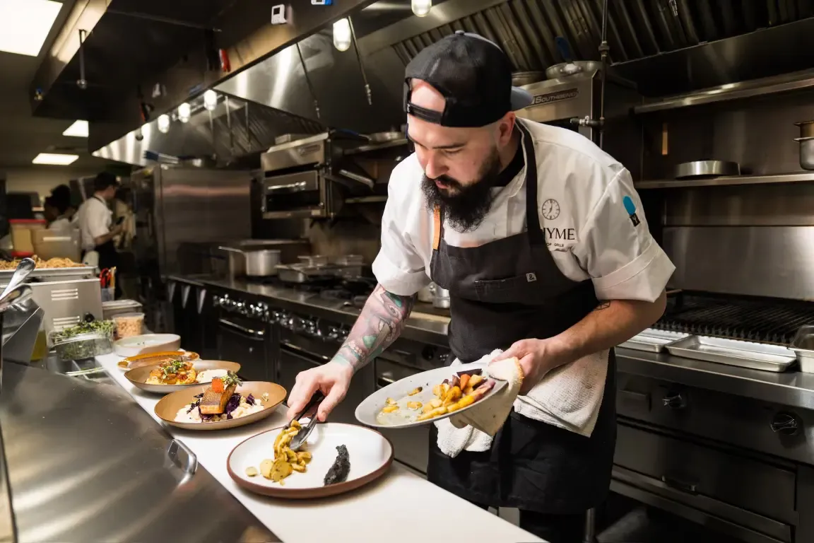 Focused chef plating a dish in a professional kitchen